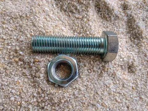 Close-up view of bolt and nut on the sand Foto stock