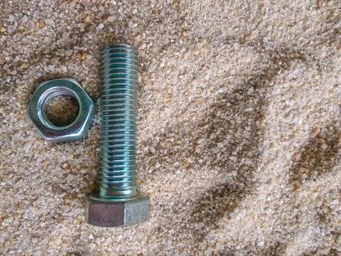 Close-up view of bolt and nut on the sand Stock Photos