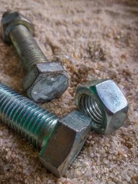 Close-up view of bolts and nuts on the sand Stock Photos