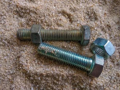 Close-up view of bolts and nuts on the sand Stock Photos