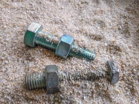 Close-up view of bolts and nuts on the sand Stock-Fotos