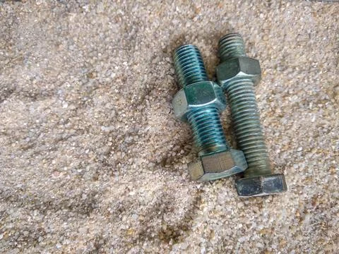 Close-up view of bolts and nuts on the sand Stock Photos
