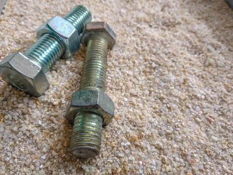 Close-up view of bolts and nuts on the sand Stock Photos