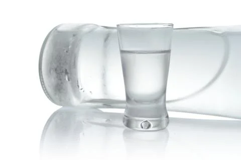 Close-up view of bottle lying and glass of vodka isolated on white Stock Photos