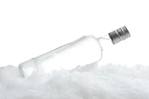Close-up view of bottle of vodka lying on ice on white Stock-Fotos