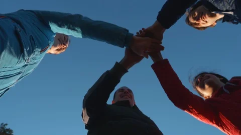 Close-up view from the bottom of the folding hands together. A happy family puts Video stock 129955813