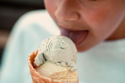 Close-up view of a boy eating ice cream in a waffle cup. Macro. Detailed view of Stock Photos