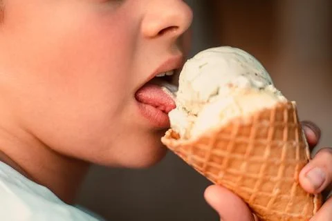 Close-up view of a boy eating ice cream in a waffle cup. Macro. Detailed view of Stock Photos