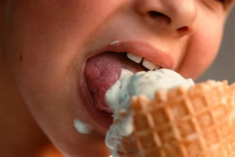Close-up view of a boy eating ice cream in a waffle cup. Macro. Detailed view of Stock Photos