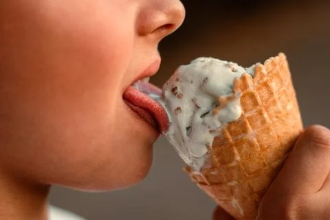 Close-up view of a boy eating ice cream in a waffle cup. Macro. Detailed view of Stock Photos