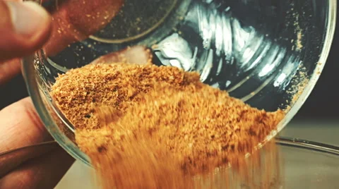 Close-up view of breadcrumbs and spices mixed together pours into a glass bow Stock Footage 65114259
