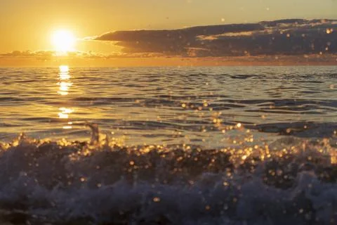 Close up view of a breaking sea wave with water droplets splashing in front.. Stock Photos
