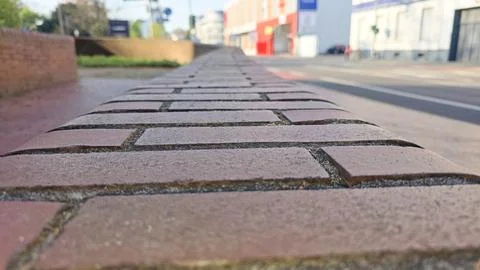 Close up view of a brick path texture, extending into a blurred city street Stock Photos