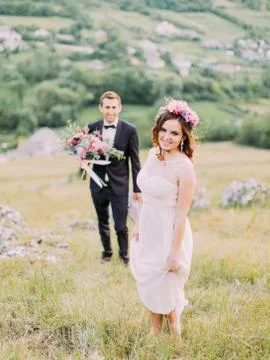The close-up view of the bride standing in the front of the blurred groom with Stock Photos