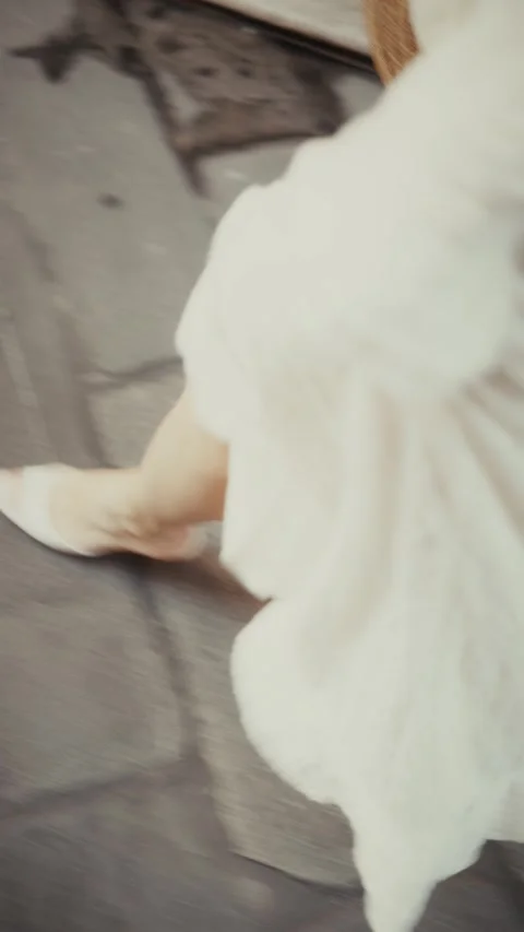Close-up view of a bride's bare feet and the hem of her white wedding dress as Vídeo Stock 346096052
