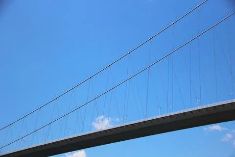 Close view of a bridge seen from below with a clear sky with a small cloud in Stock Photos