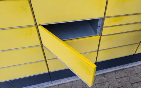 A close-up view of a bright yellow parcel locker with an open compartment. The 스톡 사진