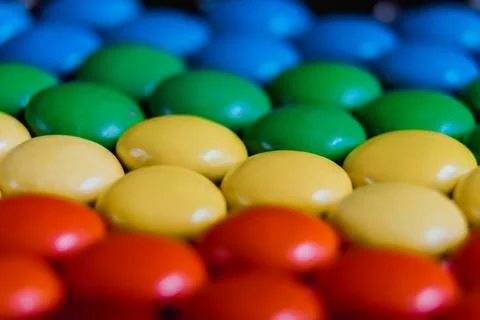 Close up view of brightly colored sweet candies laying flat. Rainbow candy ba Stock Photos