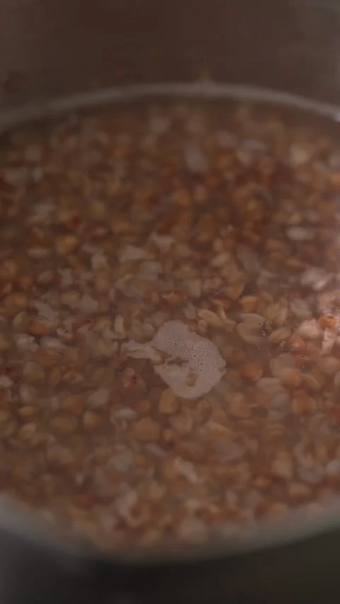 Close-up view of brown buckwheat groats boiling in hot water. Stock Footage 341242085