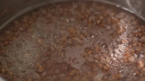 Close-up view of brown buckwheat groats boiling in hot water. Stock Footage 341242538