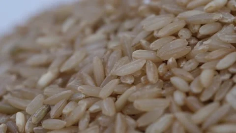 Close view of brown rice, Micro shot of rotating brown rice plate 動画素材 147689130