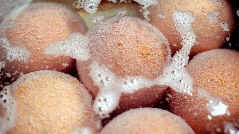 Close-up view of brown shell chicken eggs boiling in a stainless steel pan. 스톡 동영상 302715788