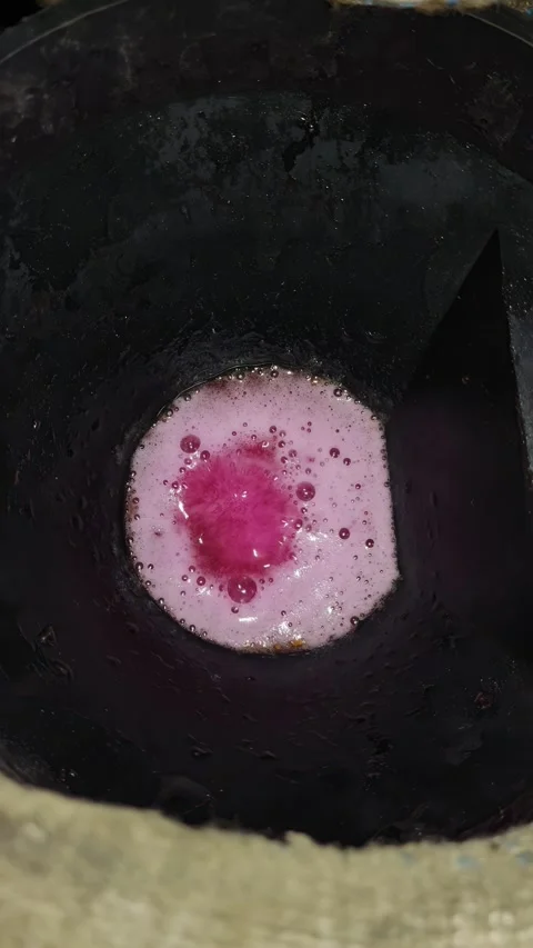 Close-up view of bubbling pink liquid in a black industrial container Stock Footage 346921029