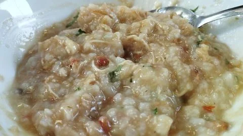 Close up view Bubur Ayam or Chicken Porridge that has been mixed with shred.. Stock Photos