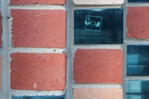 Close-up View of a Building Wall Featuring Red Clay Bricks and Reflective D.. Stock Photos