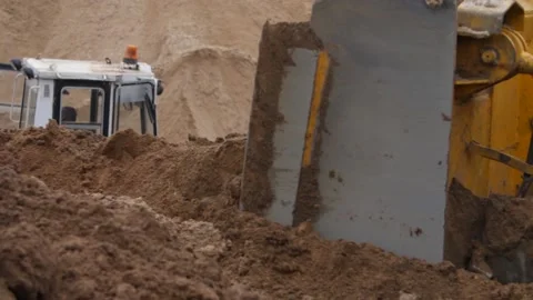 Close-up view of bulldozer moving large mass of sand with blade. Video stock 158050245