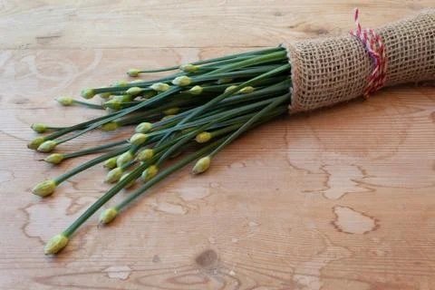 Close view of bundle of chives bound in burlap on a weathered wood background Stock Photos