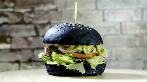 Close-up view of burger with various ingredients on a wooden board , fast food. Video stock 336579268