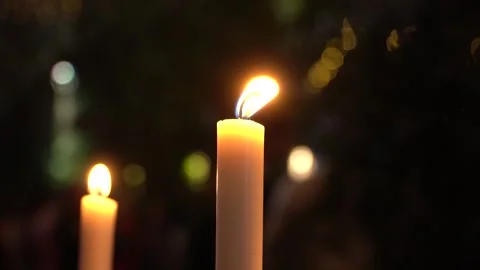 Close up view of burning candles on  a background of colored blurred bokeh. Video stock 251756602