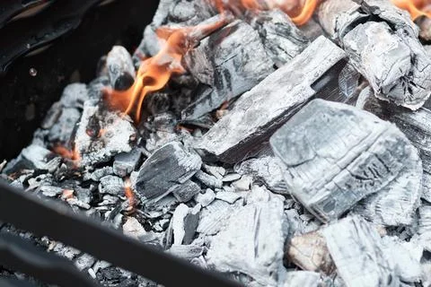 Close-up view of burning charcoal and glowing embers inside a barbecue grill Stock Photos