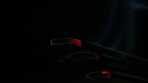 Close-up view of burning incense sticks. Smoke blows from end of hot ember Stock Footage 130566688
