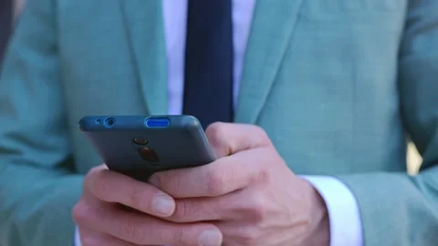 Close-up view of business man hands using smartphone device outdoors. Stock Footage 240630408
