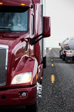 Close up view of the cab and driver of a  commercial truck on the highway. Stock Photos
