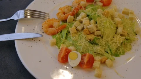Close up view of Caesar salad with shrimps served on the white plate. Video stock 104057584