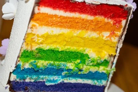 A close-up view of cake with brightly colored rainbow layers and delicious Stock Photos