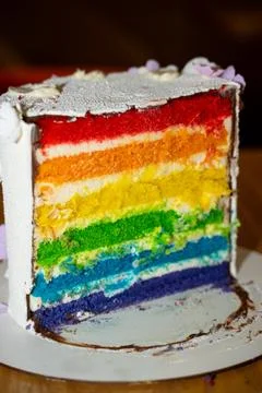 A close-up view of cake with brightly colored rainbow layers and delicious Stock Photos