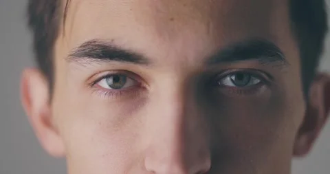 A close-up view of a calm handsome young man is opening his eyes and looking to Video stock 148396098