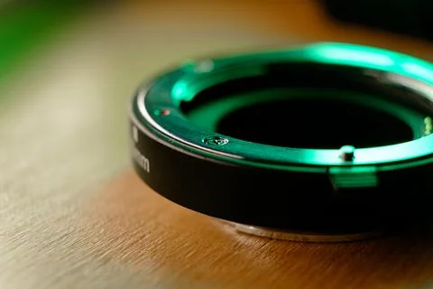 Close-up view of a camera lens mount with green lighting effect at home Photos