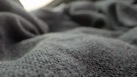 Close-up view of a camera moving across textured cloth, its weave and folds.. Stock Footage 259158769