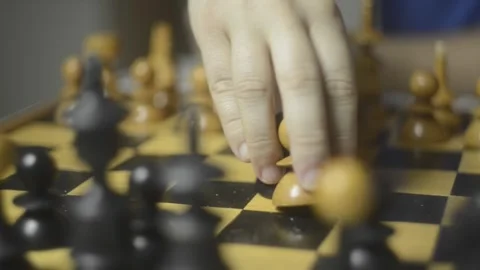 A close-up view captures a hand making a strategic move on a chessboard Stock Footage 347595555