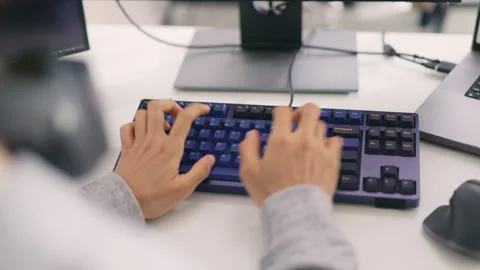 A close-up view captures a programmer's hands as they swiftly navigate a mech Stock Footage 310589138