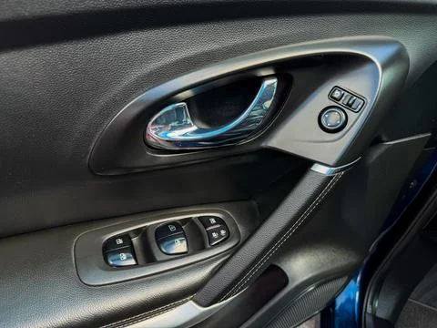 A close view of a car door panel captures the window control buttons and the  Stock Photos
