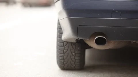 Close up view car exhaust pipe and wheel, vehicle move away with sound and smoke Stock Footage