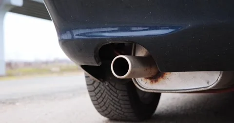 Close-up view of a car exhaust pipe showing gradual angle change, revealing tire Stock Footage 330050696