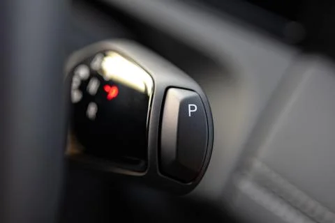 Close-up view of a car gear shift lever with a parking button illuminated, .. Stock Photos