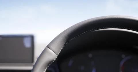 Close view of a car steering wheel with dashboard in the background at sunset Stock Illustration